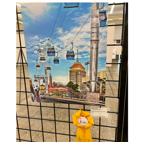 An artwork we designed entitled Moving Attraction that shows an aerial tram going down the middle of Blackstone Ave. It is attached with a "Best of Show" ribbon.